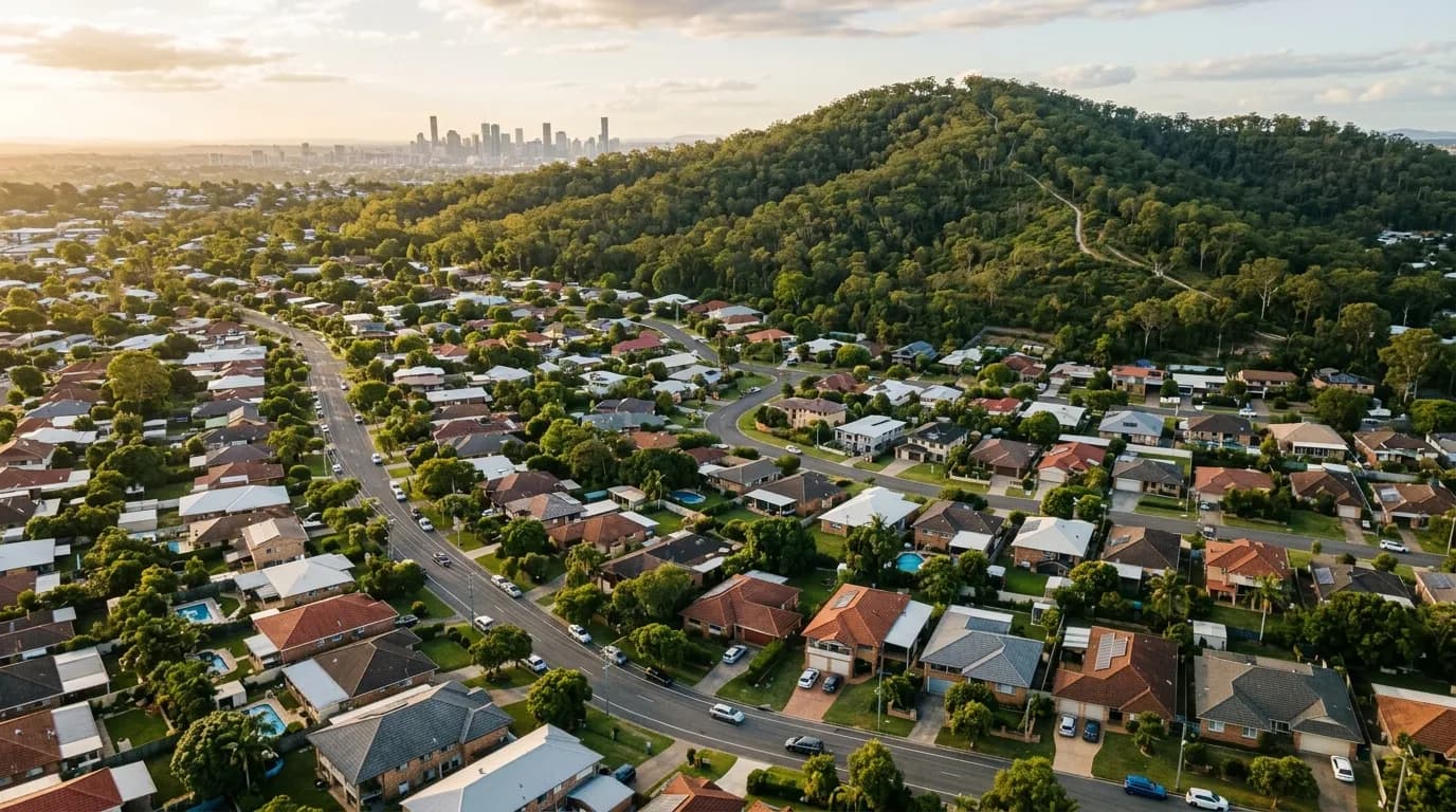 Aerial view of leafy southside Brisbane streets with a bushland hill rising behind
